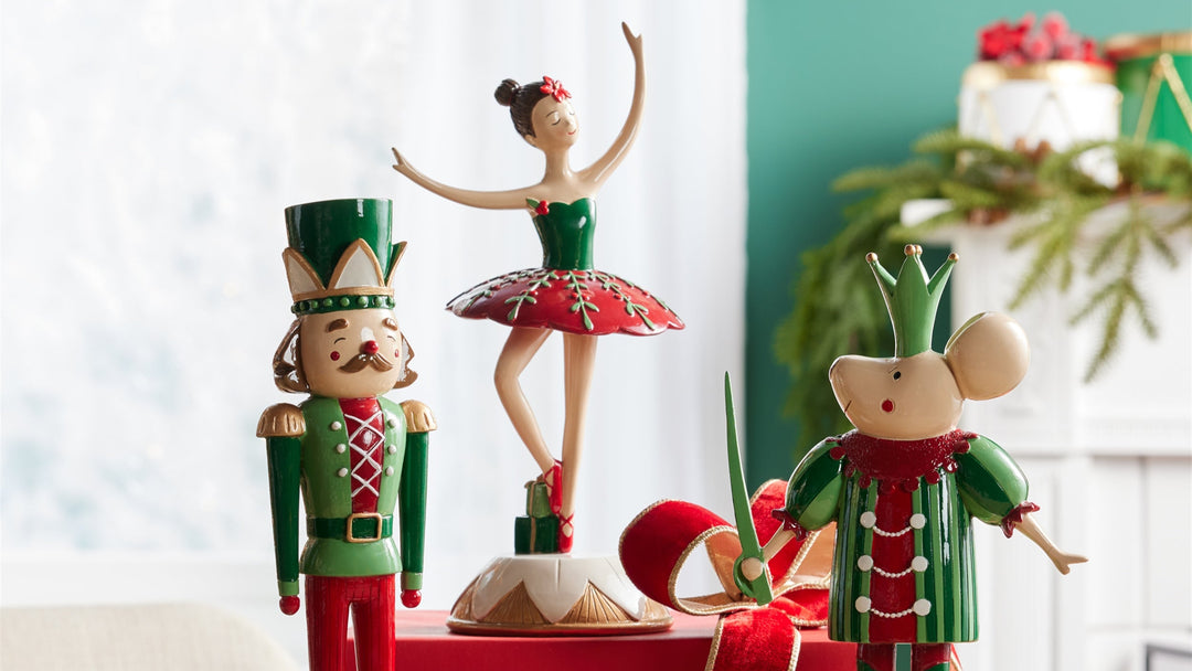 Decorative Christmas figurines on a wooden surface with a festive background.